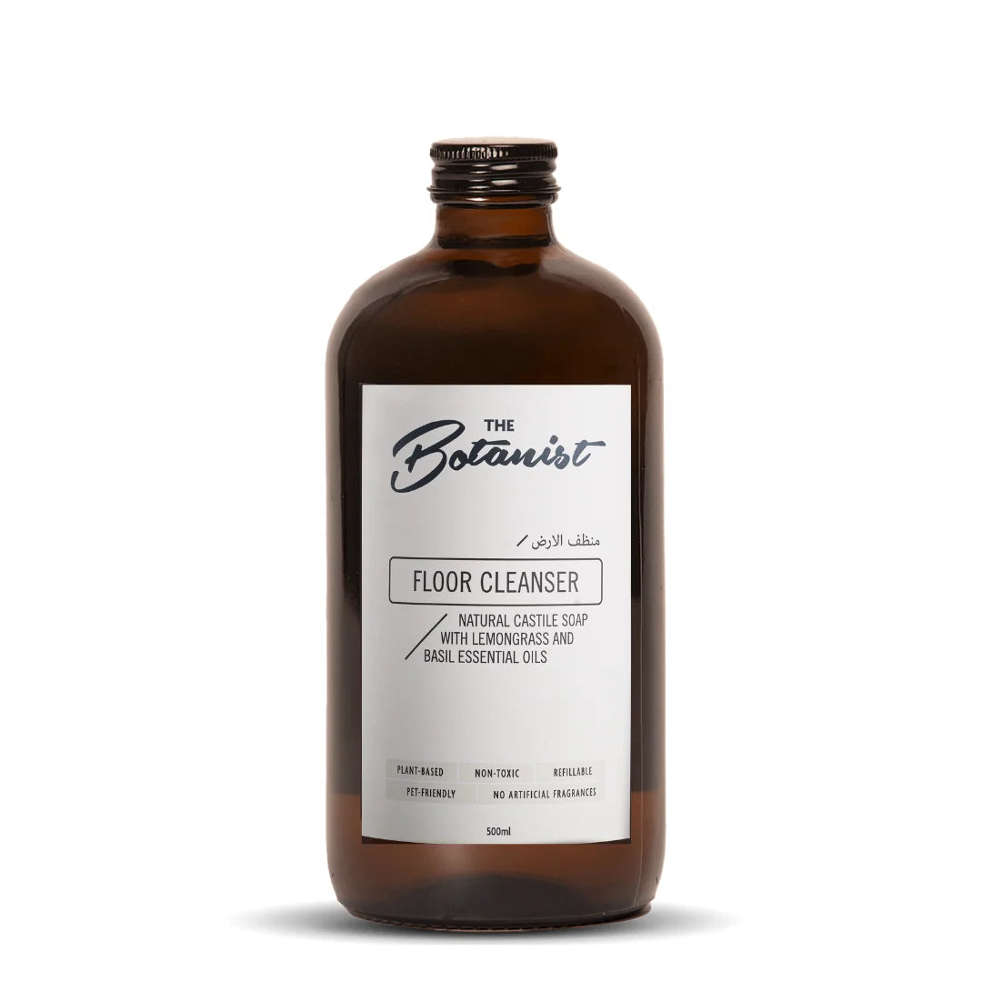 An amber glass bottle of The Botanist Floor Cleanser with a white label, set against a plain white background.