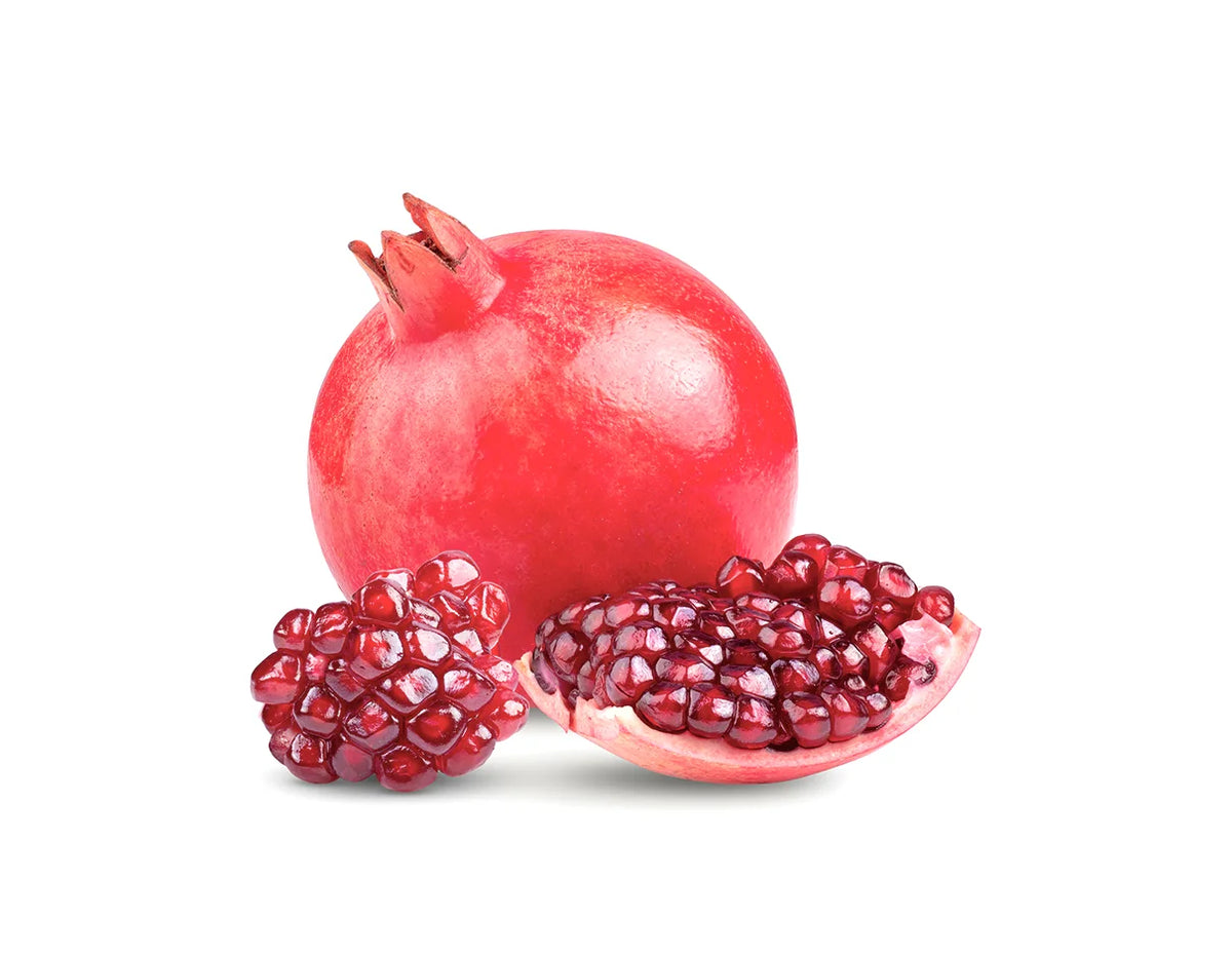 A whole red pomegranate with two halves cut open in front, showing the deep red arils, isolated on a white background.