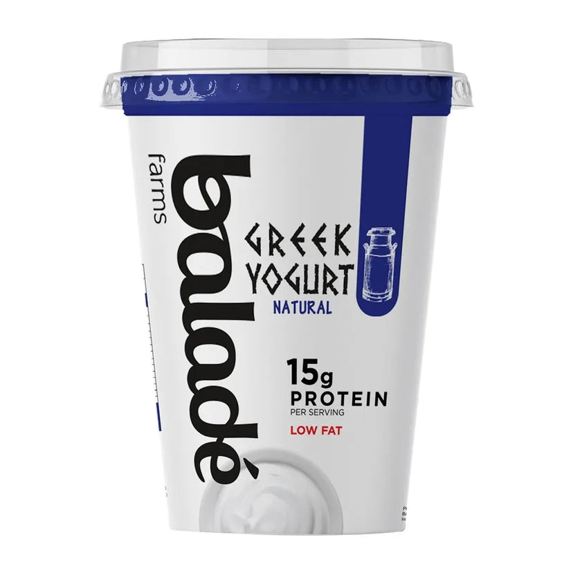 A container of Balade Farms Greek Yogurt, Natural flavor, 15g protein per serving, low fat. The white plastic tub features a blue lid seal, a blue vertical stripe, and black branding text.