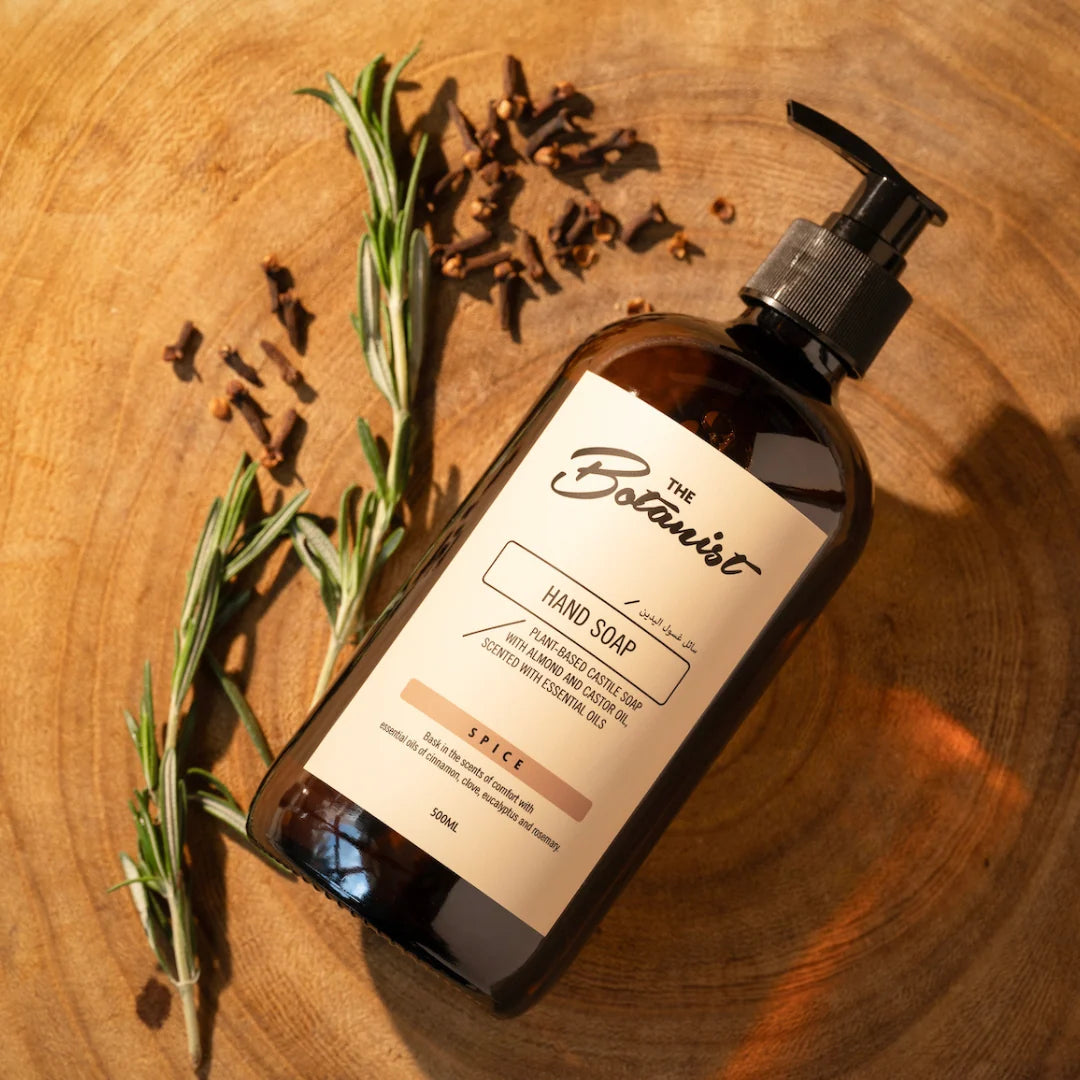 Hand soap bottle with botanical label on a wooden surface with herbs