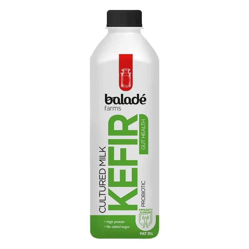 A bottle of Baladé Farms Cultured Milk Kefir, probiotic, with a white bottle, green and black text, and a black cap on a white background.