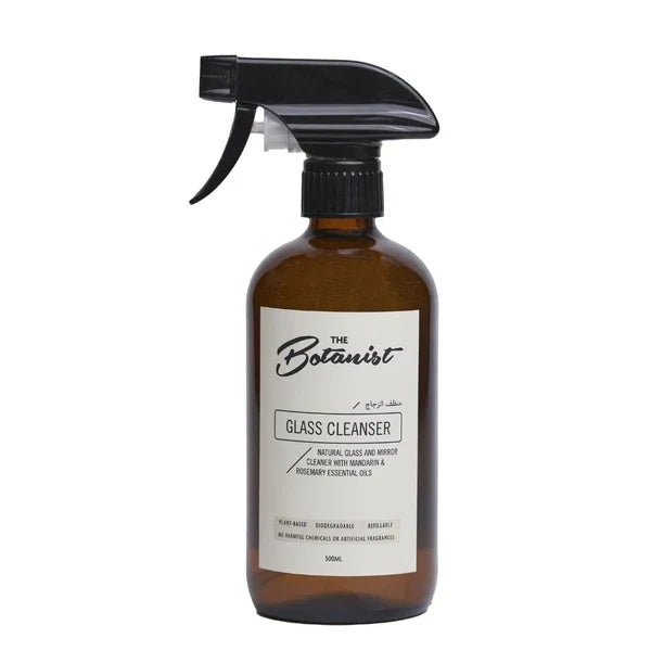 Brown glass cleaner bottle with black spray nozzle on a white background