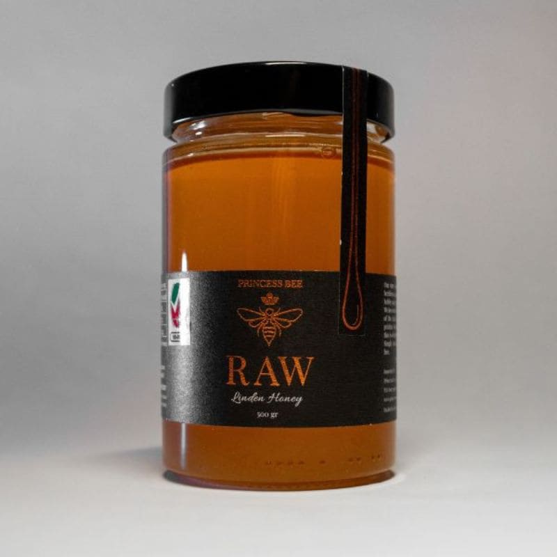 A 300g glass jar of Princess Bee Raw Lidia Honey, filled with golden amber honey and featuring a black label with gold lettering and a black screw cap, set against a neutral gray background.