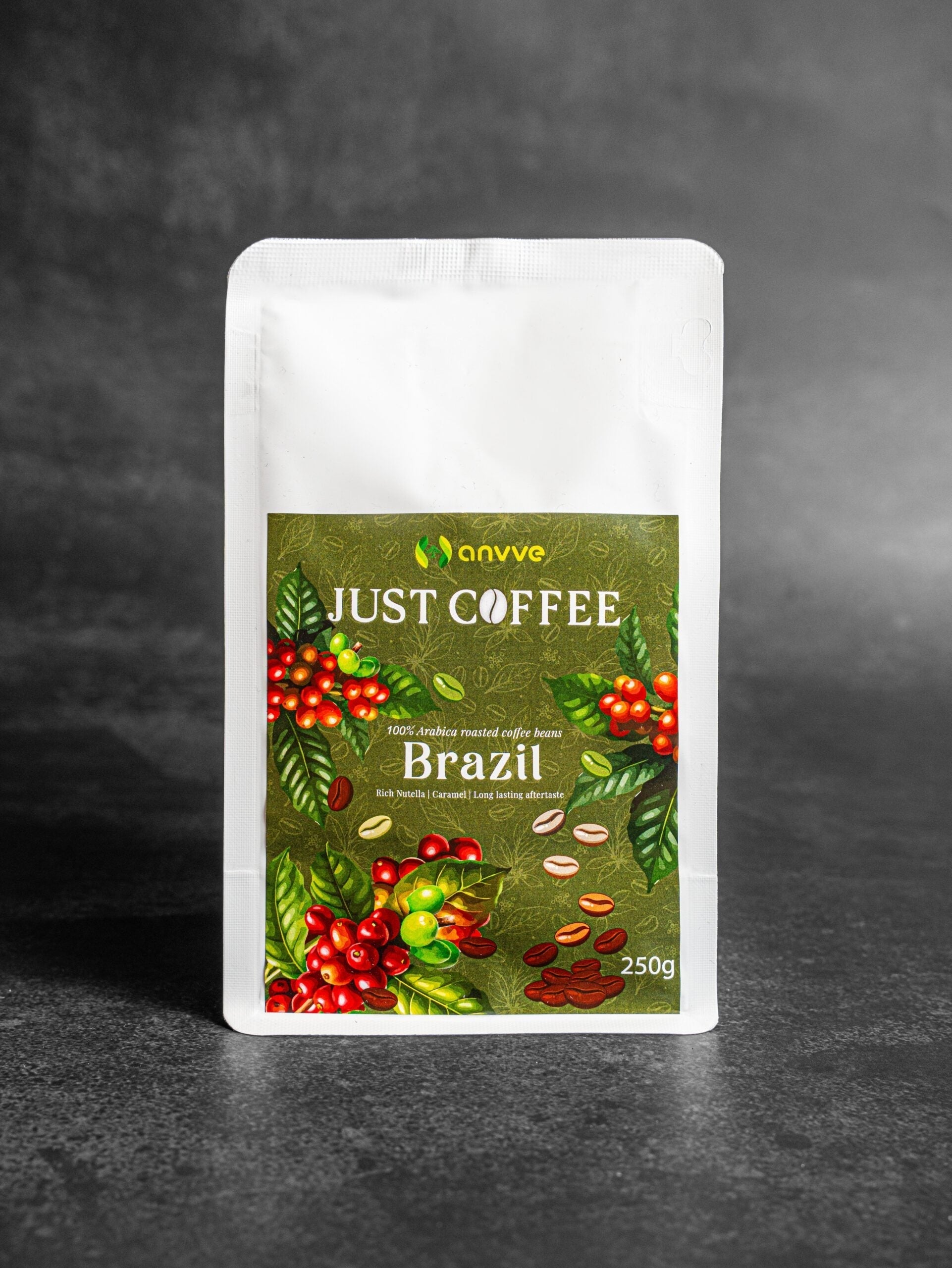 A 250g stand-up pouch of Anvve Just Coffee Brazil, featuring a white pouch with a green label decorated with illustrations of coffee cherries and beans, set against a dark gray textured background.