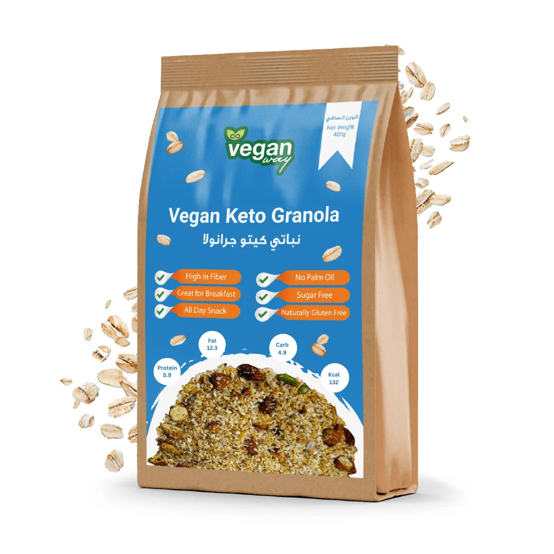 A stand-up pouch of Vegan Keto Granola on a white background, with scattered oats around it. The package is tan with a large blue front panel and shows the Vegan Energy brand logo.