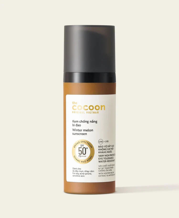 A bottle of Be Cocoon Originals Vietnam Winter Melon Sunscreen, featuring a brown bottle, black cap, and a white label with gold and black text, set against a solid light beige background.