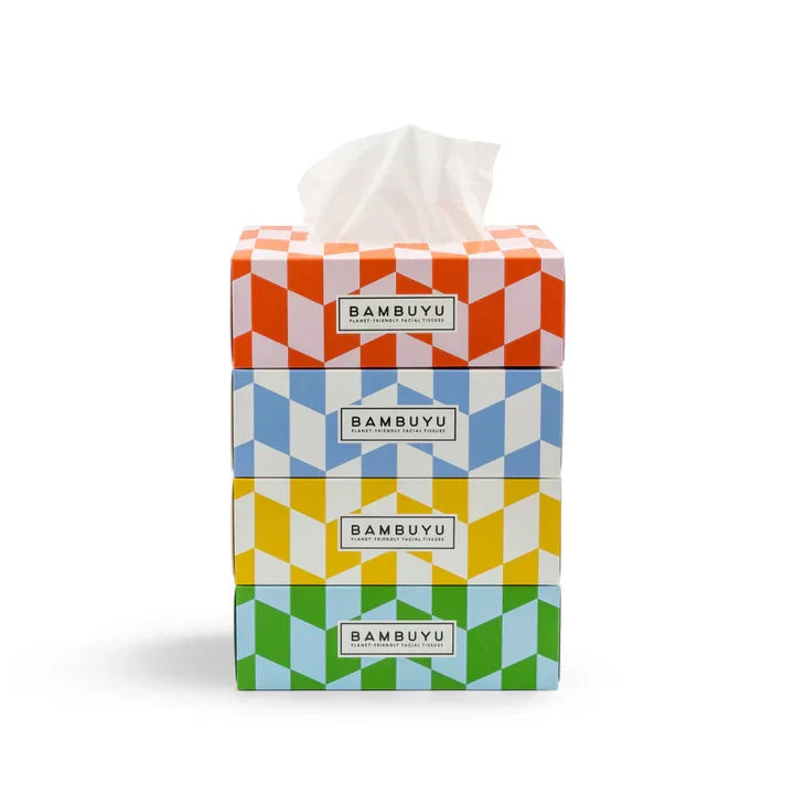 Four stacked BAMBUYU tissue boxes with a colorful geometric pattern, showing orange, blue, yellow, and green designs, with white tissues visible at the top, on a white background.