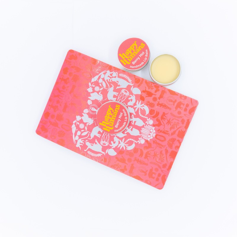 A coral pink and white patterned lip balm tin with a round silver tin of pale yellow balm next to it, both featuring a red and yellow 'Pup' logo, on a clean white background.