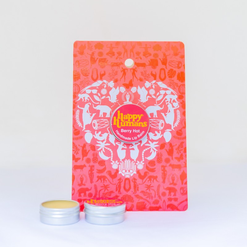 A red and orange patterned Happy Hapkase Berry Hot Handmade Lip Balm packaging card, shown with two small silver metal tins of the balm in front on a clean white background.