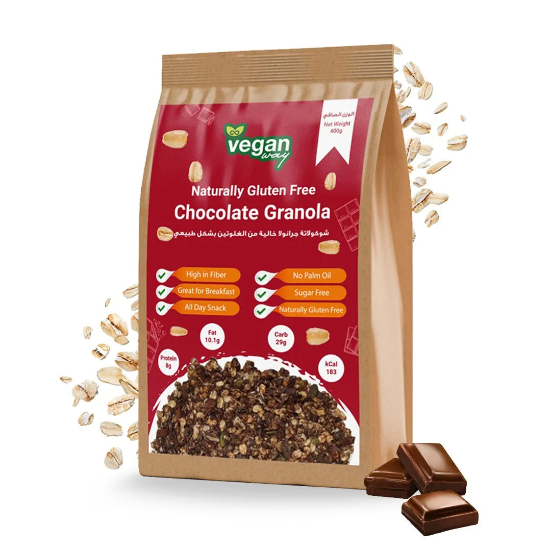 A stand-up pouch of Vegan Wrap Chocolate Granola on a white background, with scattered oats and chocolate pieces around it. The package is kraft brown with a large red front panel and product imagery of dark chocolate granola and milk chocolate squares.