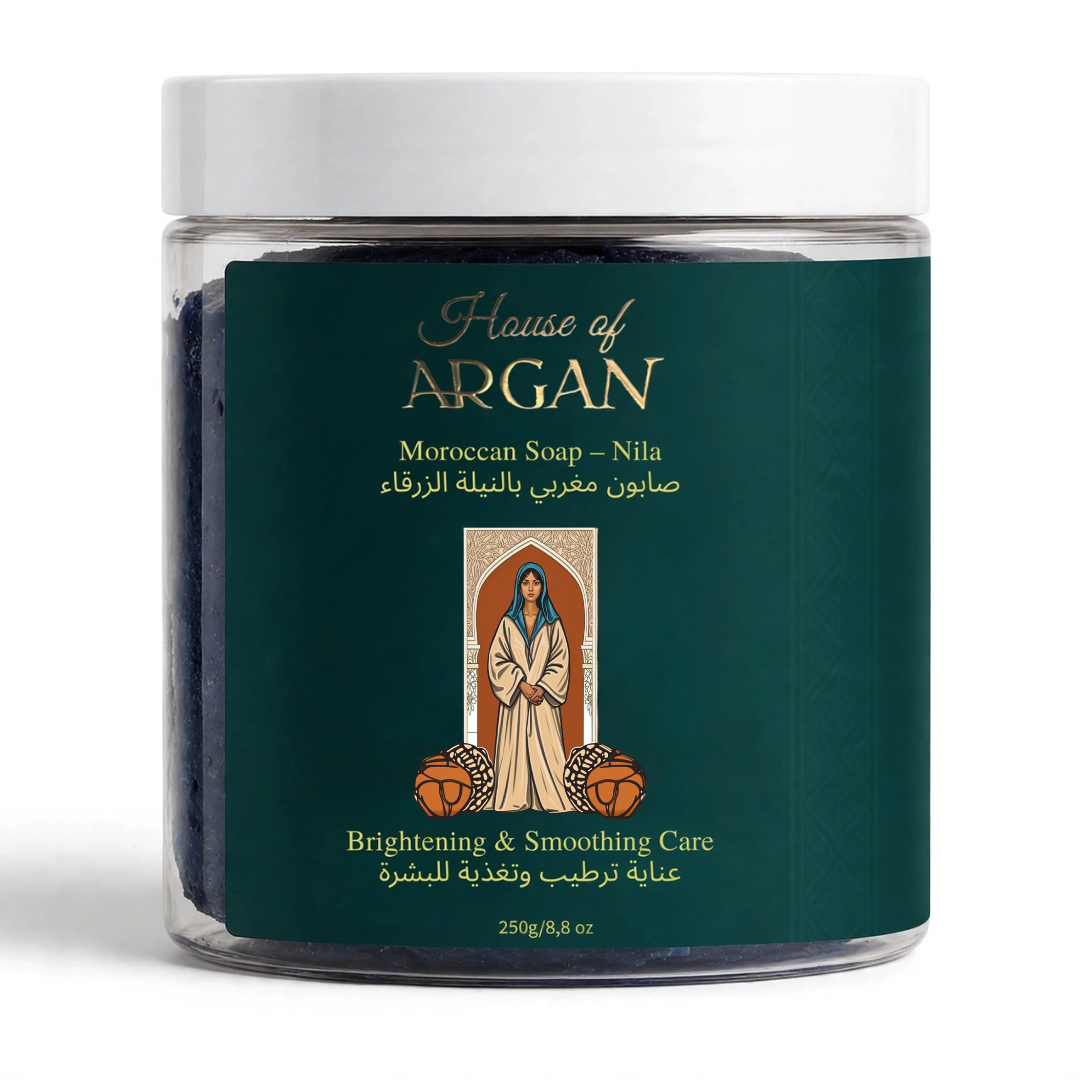 A clear plastic jar of House of Argan Moroccan Soap - Nila, featuring a dark green label with gold lettering and a central illustration of a woman, topped with a white lid.