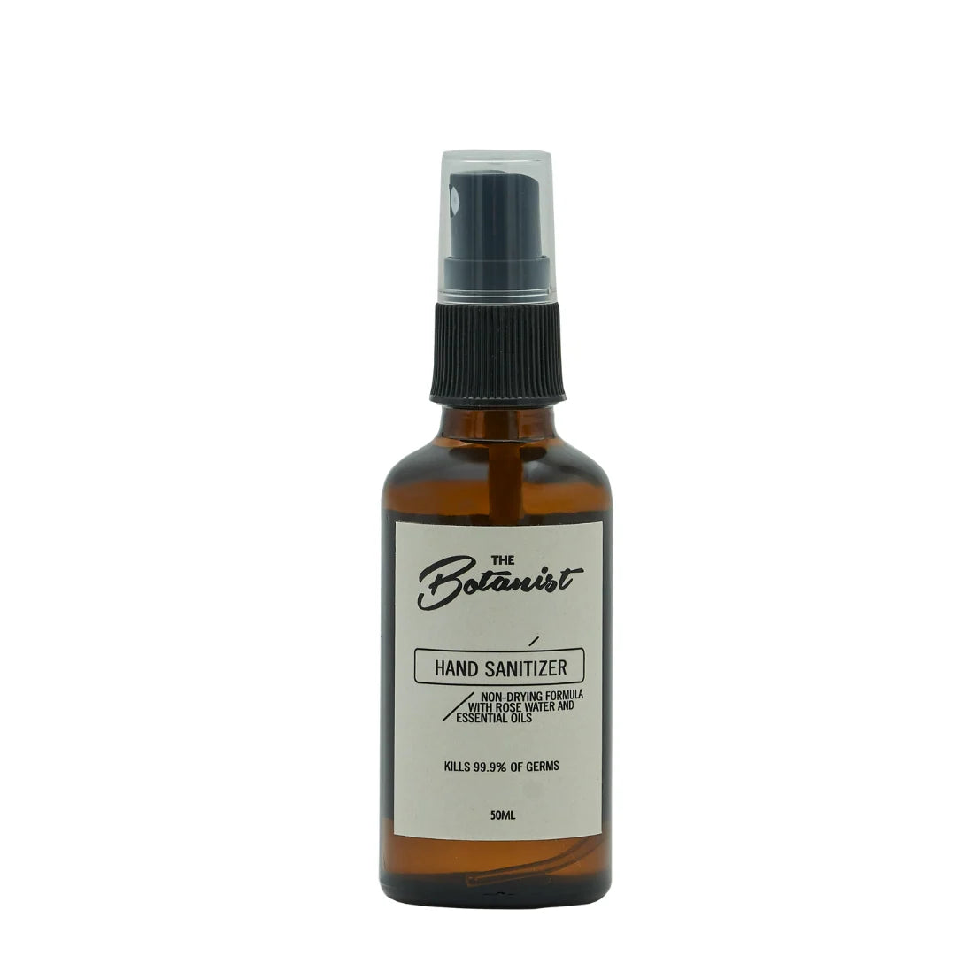 A 50ml amber glass hand sanitizer bottle with a black spray cap and a white label reading 'The Botanist'.