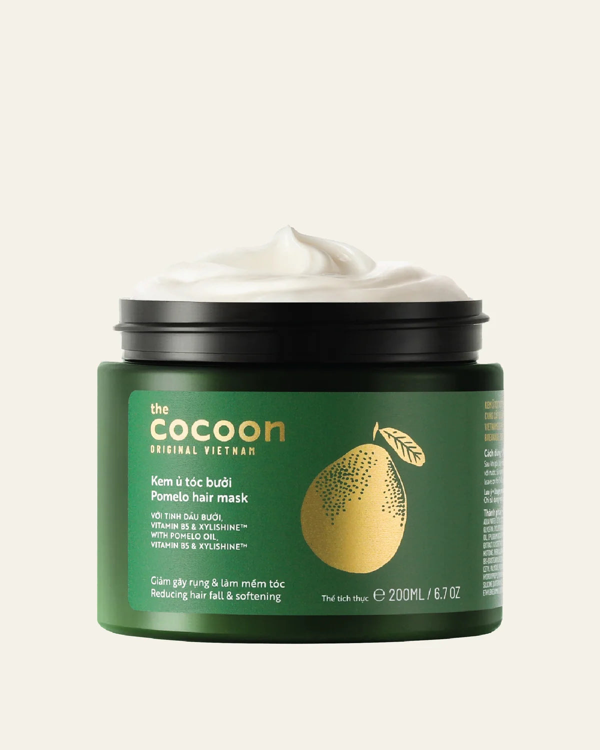 A jar of 'The Cocoon' Original Vietnam Pomelo Hair Mask with a white cream product visible at the open black lid, set against a solid off-white background.